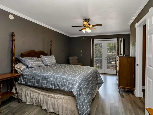 a bedroom with a bed dresser and a large window