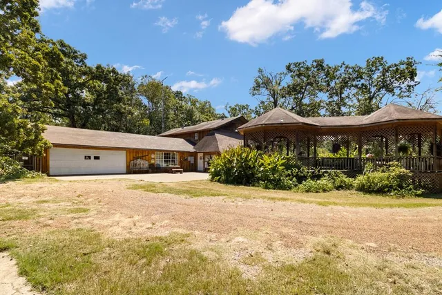 a front view of house with yard and trees in the background