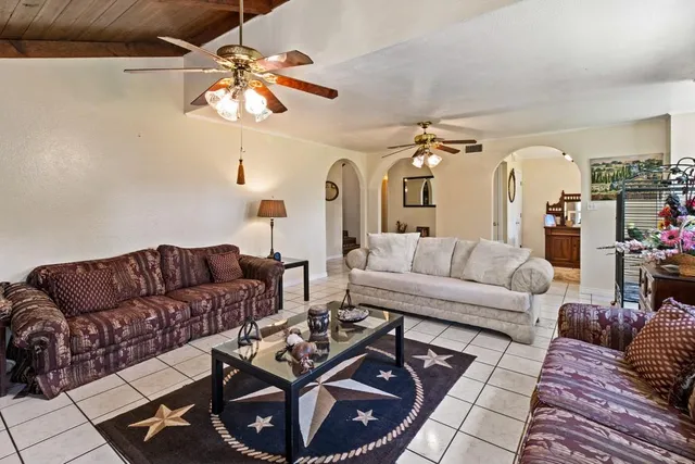 a living room with furniture a chandelier and a rug