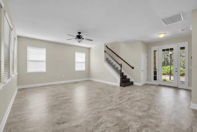an empty room with windows and stairs