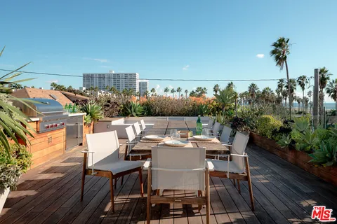 a view of a patio with table and chairs potted plants with wooden floor