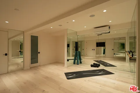 a room with gym equipment and large mirror