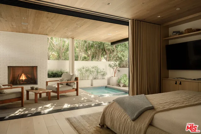 a bedroom with a bed and large windows