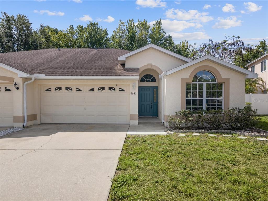 8640 Hawbuck Street Trinity, FL 34655 - Photo 1 of 1 a front view of a house with a yard