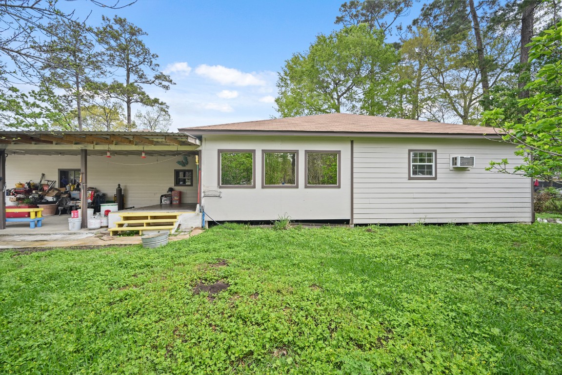 2137 Honey Tree Street Conroe, TX 77385 - Photo 2 of 13 a view of a backyard with table and chairs and a large tree