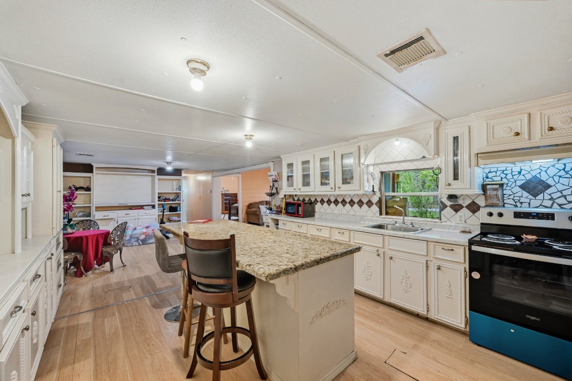 2137 Honey Tree Street Conroe, TX 77385 - Photo 5 of 13 a kitchen with a table chairs stove and cabinets