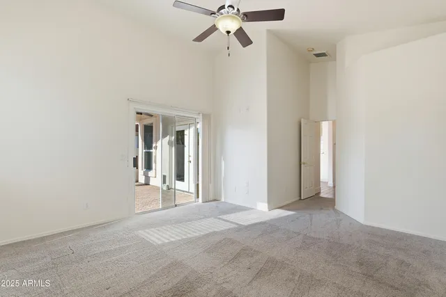 a view of a room with a ceiling fan and a window