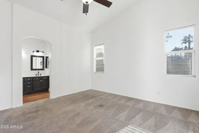 an empty room with windows and cabinet
