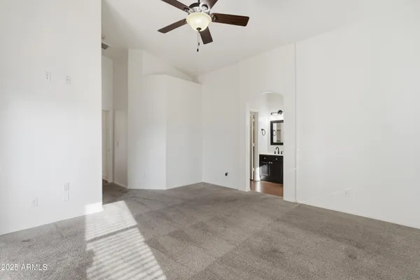an empty room with fan and windows