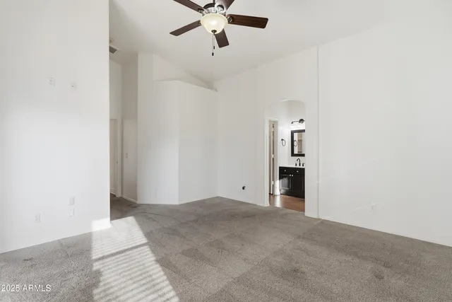an empty room with fan and windows