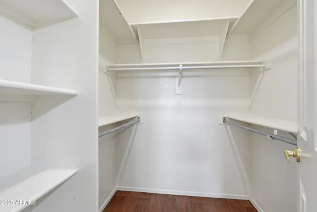 a view of walk in closet with empty racks