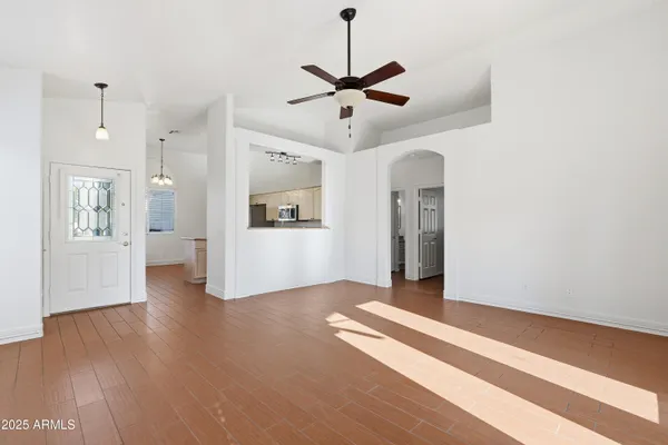 a view of a livingroom with wooden floor and a ceiling fan
