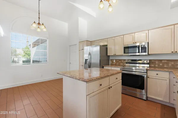 a kitchen with stainless steel appliances granite countertop a stove a sink and a refrigerator
