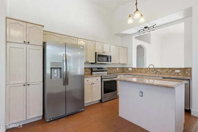a kitchen with stainless steel appliances a sink stove and refrigerator