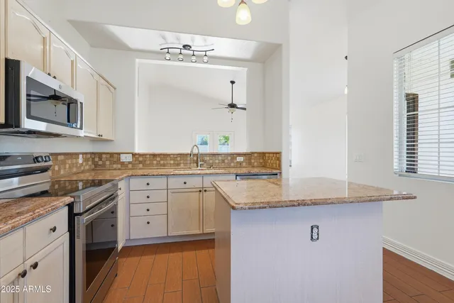 a kitchen with stainless steel appliances granite countertop a sink and dishwasher a stove with wooden floor