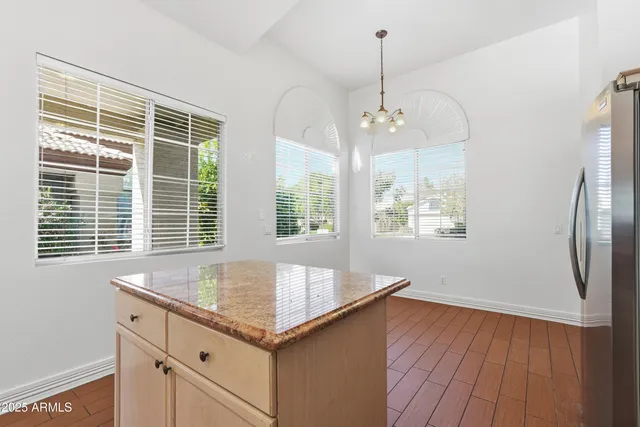 a view of kitchen with granite countertop window and refrigerator