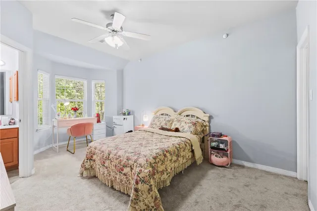 a bedroom with a bed a window and flat screen tv