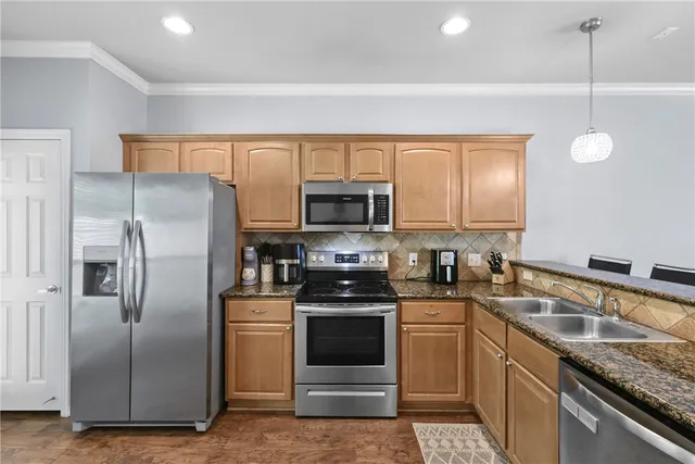 a kitchen with stainless steel appliances granite countertop a refrigerator and a stove top oven