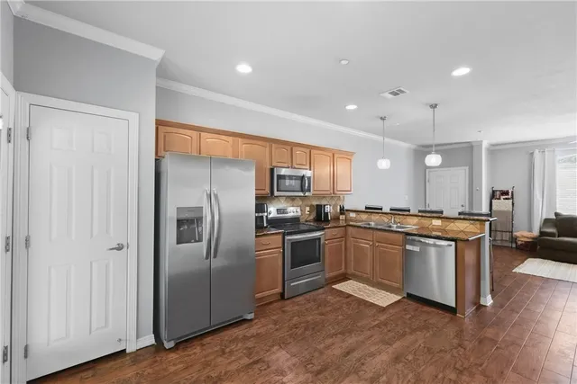 a kitchen with stainless steel appliances granite countertop a stove a sink and a microwave