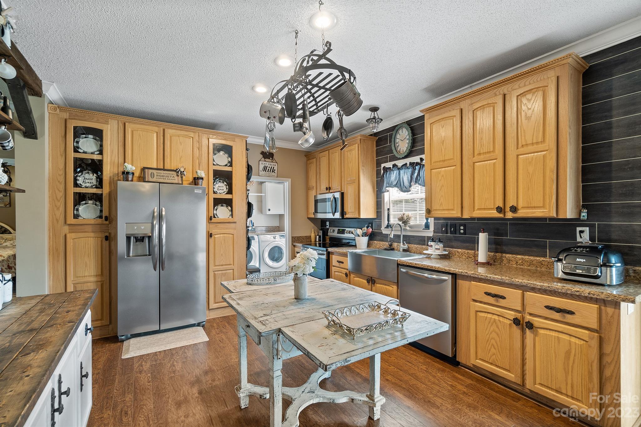 515 Brawley Road Cleveland, NC 27013 - Photo 19 of 39 a kitchen with stainless steel appliances granite countertop a refrigerator a sink dishwasher a stove and a dining table with wooden floor