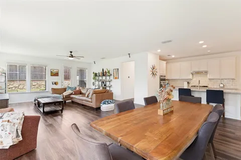 a living room with furniture wooden floor and kitchen view