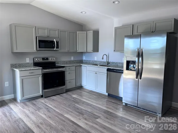 a kitchen with stainless steel appliances granite countertop a stove a sink and a refrigerator