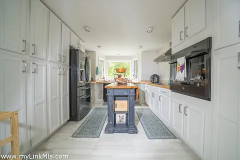 a kitchen with stainless steel appliances granite countertop a refrigerator and a sink