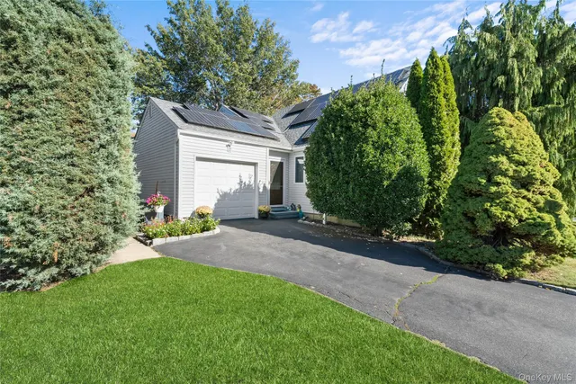 a front view of a house with a yard and plant