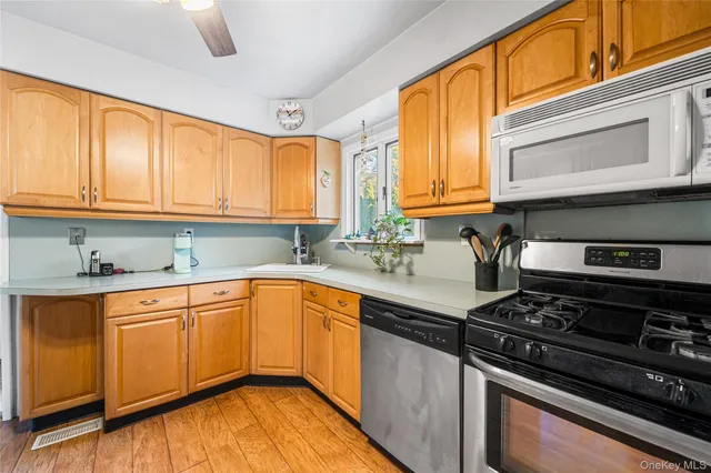 a kitchen with stainless steel appliances granite countertop a sink a stove and cabinets