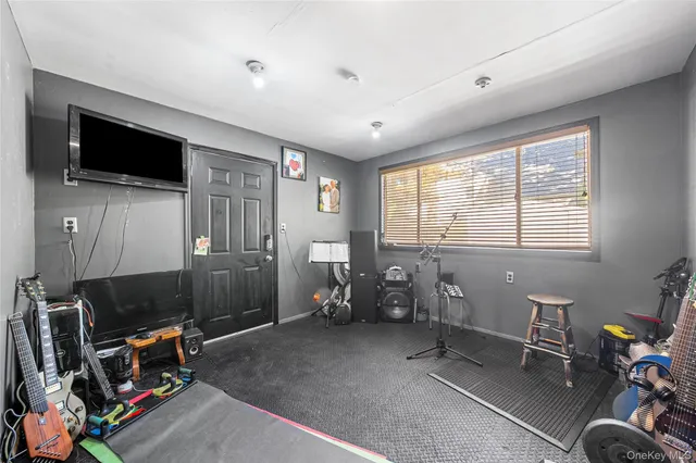 a living room with furniture a flat screen tv and a window