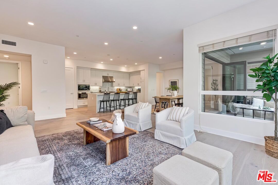 12771 Shell Place, Unit 2 Los Angeles, CA 90094 - Photo 8 of 39 a living room with furniture a table and kitchen view