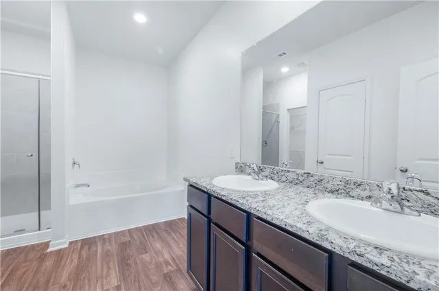 a bathroom with a granite countertop sink mirror and bathtub