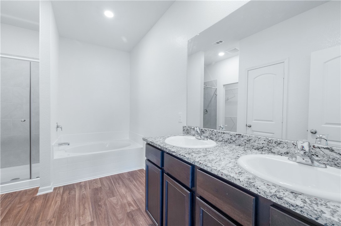 18513 Quiet Range Drive Elgin, TX 78621 - Photo 12 of 28 a bathroom with a granite countertop sink mirror and bathtub