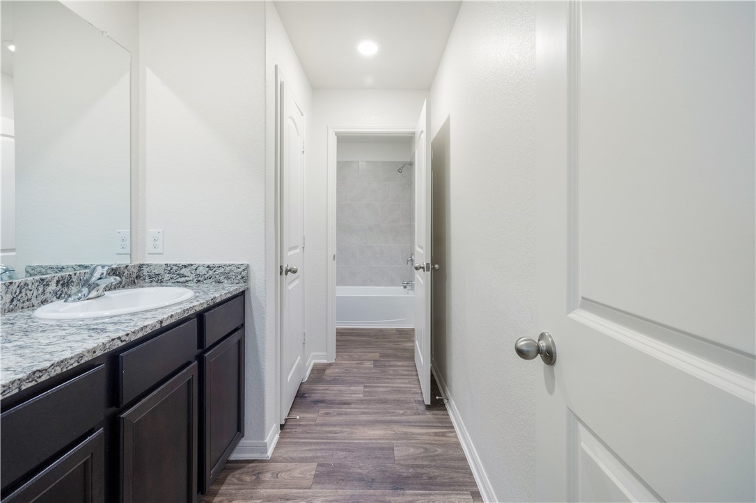 18513 Quiet Range Drive Elgin, TX 78621 - Photo 22 of 28 a bathroom with a granite countertop sink and a mirror