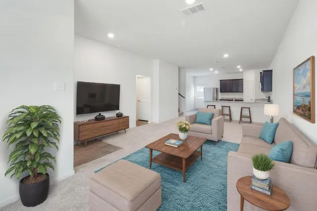 a living room with furniture a flat screen tv and a potted plant