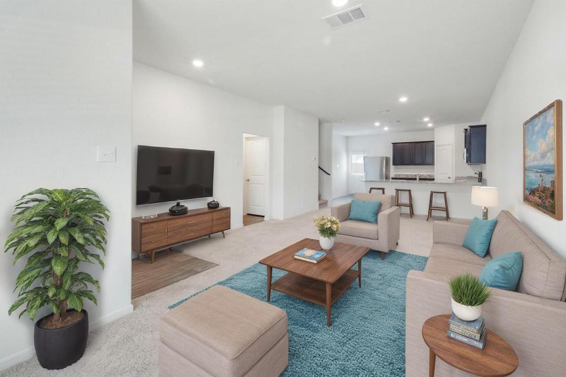 18513 Quiet Range Drive Elgin, TX 78621 - Photo 4 of 28 a living room with furniture a flat screen tv and a potted plant