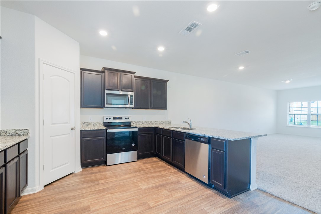 18513 Quiet Range Drive Elgin, TX 78621 - Photo 8 of 28 a large kitchen with cabinets and stainless steel appliances