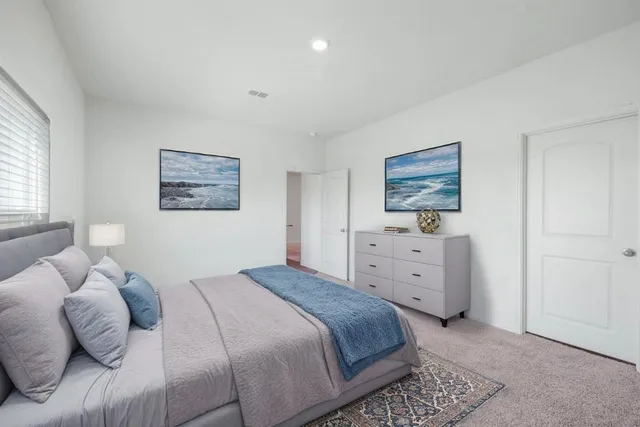 a bedroom with a bed and a painting on the wall