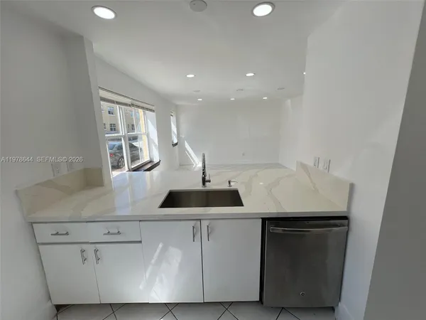 a kitchen with a sink and wooden floor