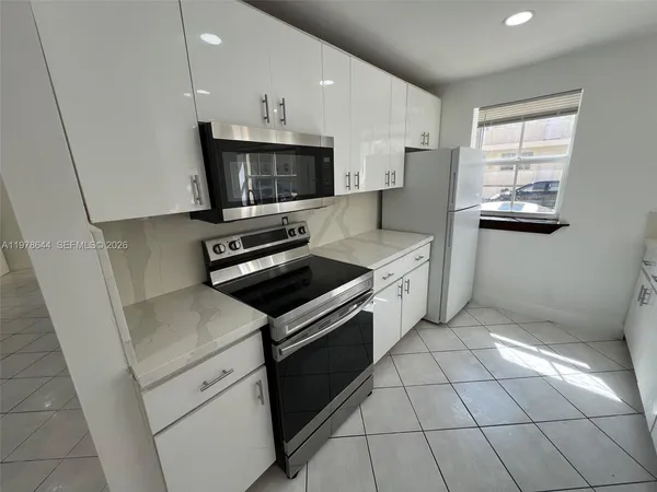a kitchen with stainless steel appliances a sink a stove a microwave and cabinets