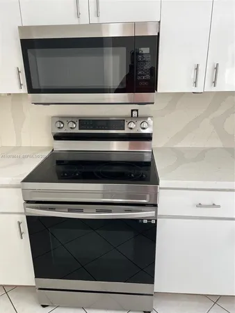 a kitchen with a refrigerator sink stove and cabinets