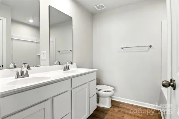 a bathroom with a sink a toilet and a mirror
