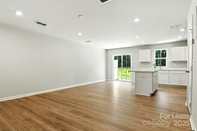 a view of a kitchen with wooden floor and electronic appliances