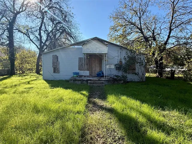 a view of a house with a yard patio and fire pit
