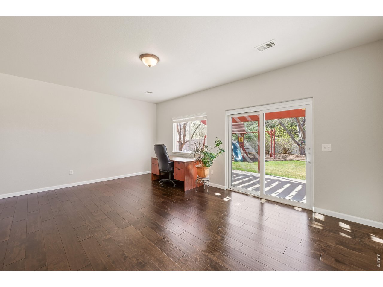 9877 Buffalo Street Firestone, CO 80504 - Photo 11 of 40 a view of an empty room with wooden floor and a window