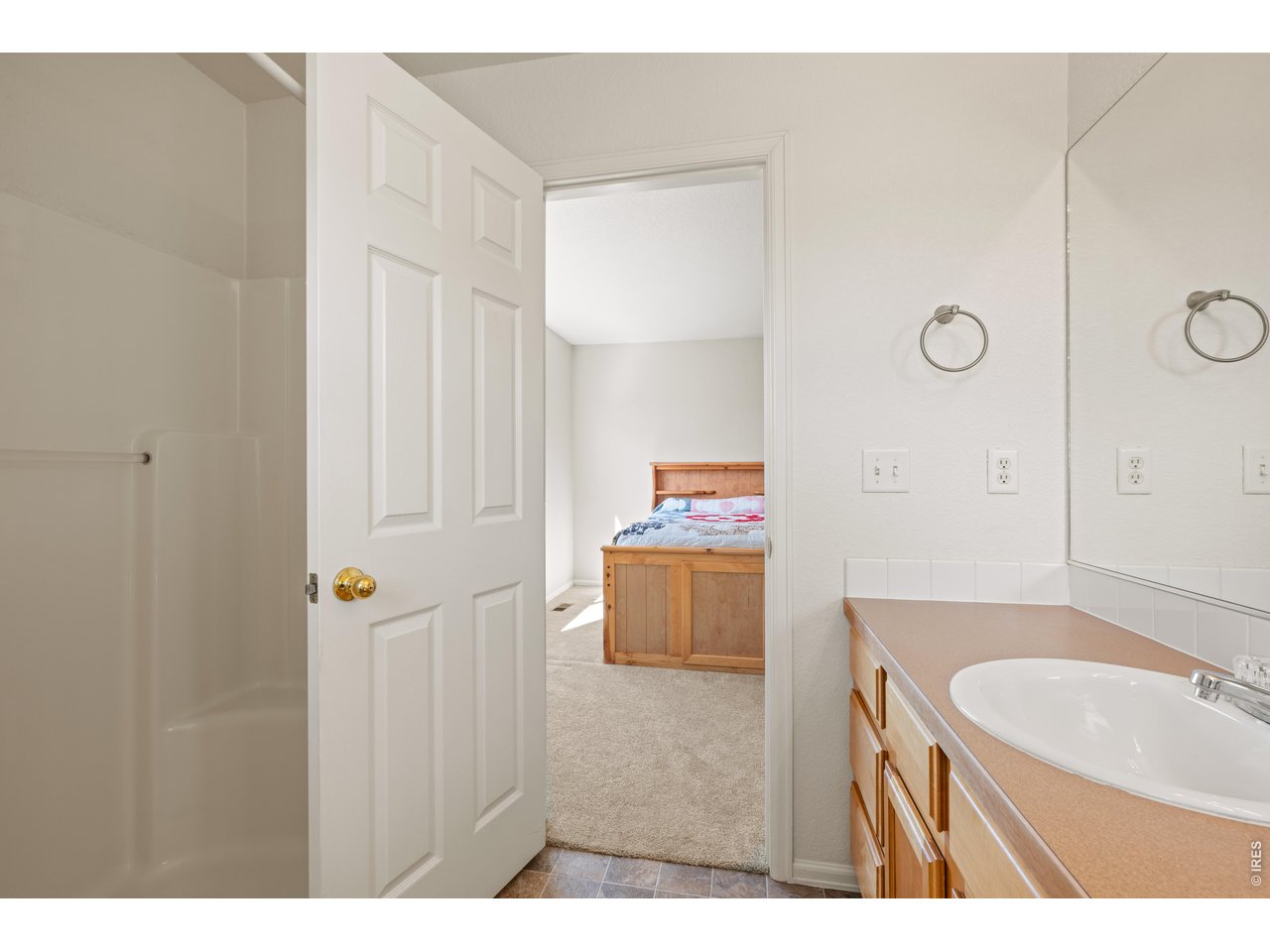 9877 Buffalo Street Firestone, CO 80504 - Photo 21 of 40 a bathroom with a granite countertop sink a mirror and a shower