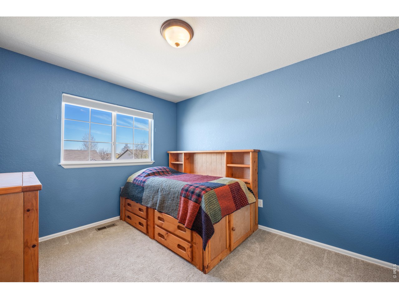 9877 Buffalo Street Firestone, CO 80504 - Photo 27 of 40 a bed sitting in a bedroom next to a window
