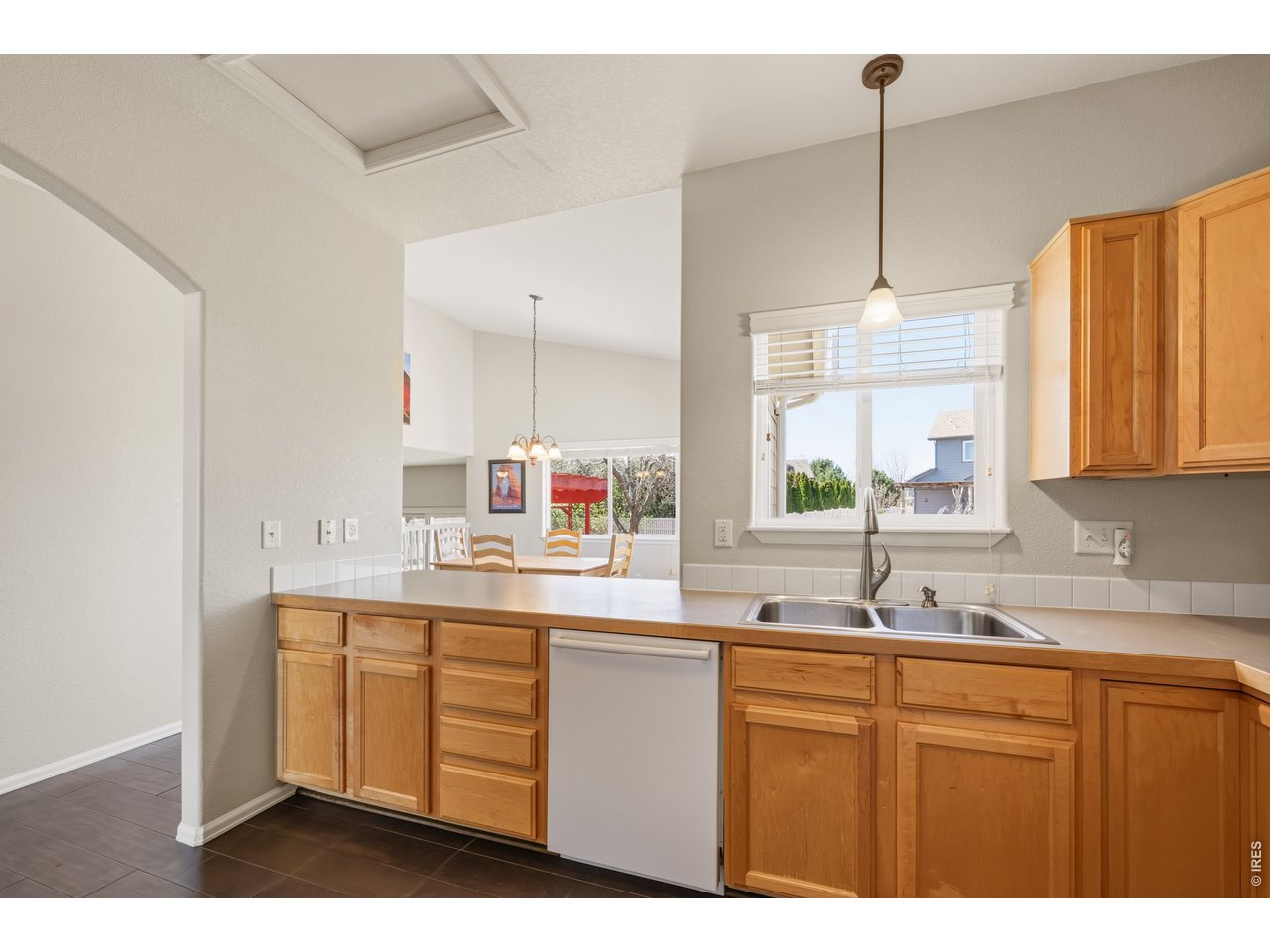 9877 Buffalo Street Firestone, CO 80504 - Photo 9 of 40 a kitchen with kitchen island granite countertop a sink a stove and cabinets