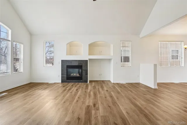 a view of empty room with wooden floor and fireplace