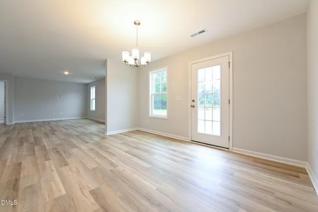 a view of empty room with wooden floor and window